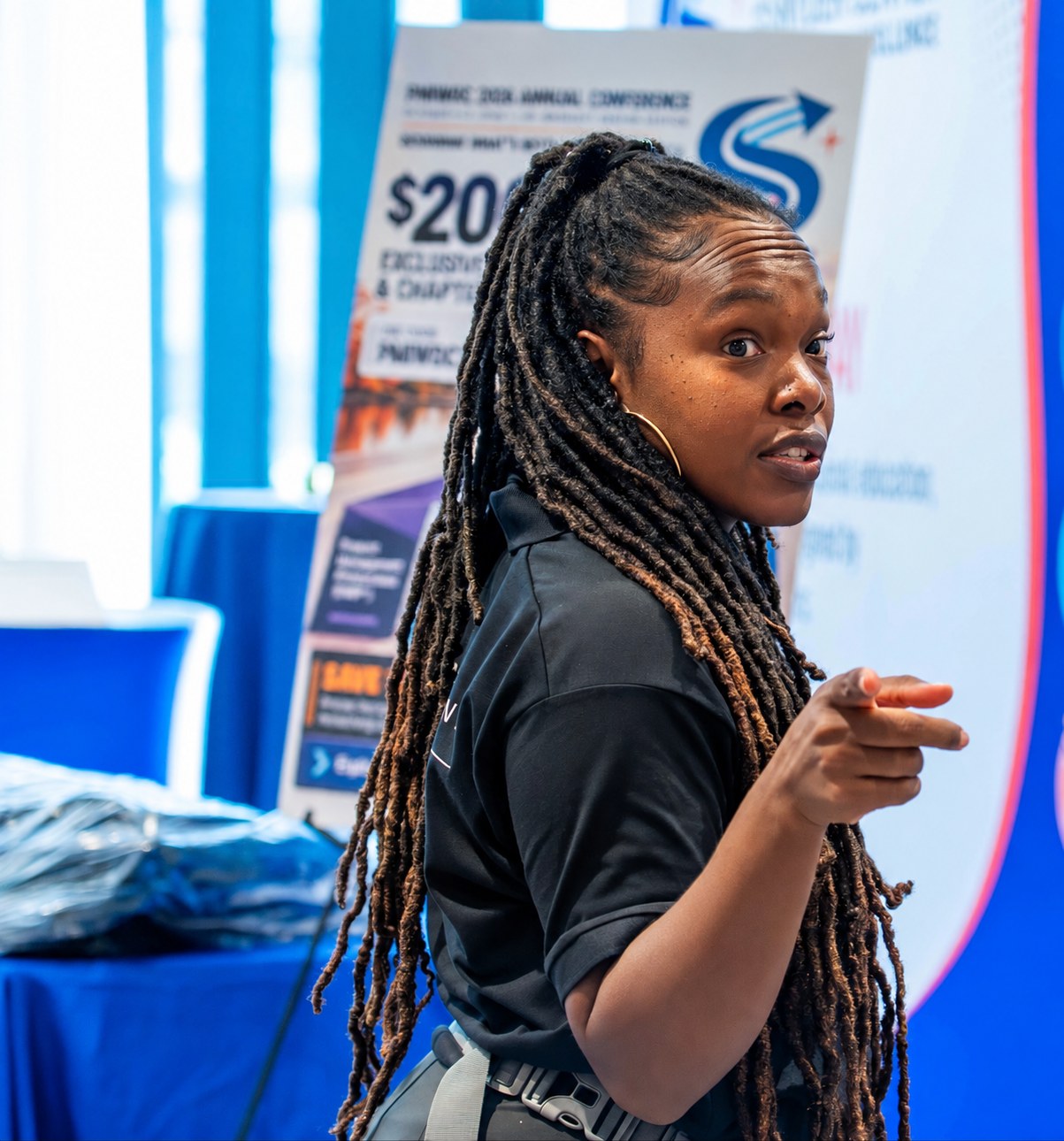Fayola Whyte-Manco, Creative Motion Events event director, directing setup in front of the PMIWDC 2026 Annual Conference banner at the PMI Washington DC Chapter Awards Gala