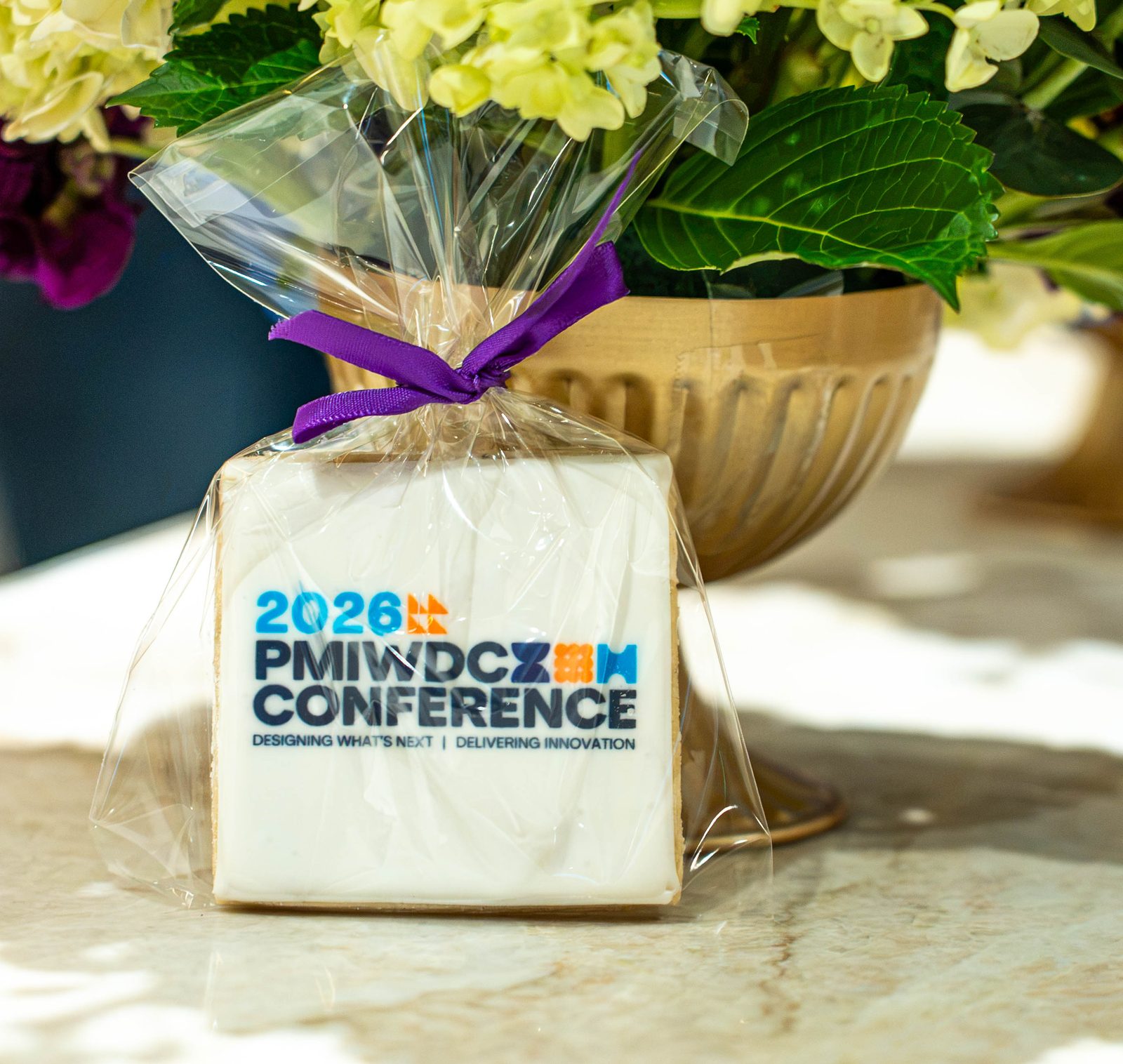 Custom 2026 PMIWDC Conference logo cookie tied with a purple ribbon, a branded favor at the PMI Washington DC Chapter Awards Gala, JW Marriott Reston, Virginia
