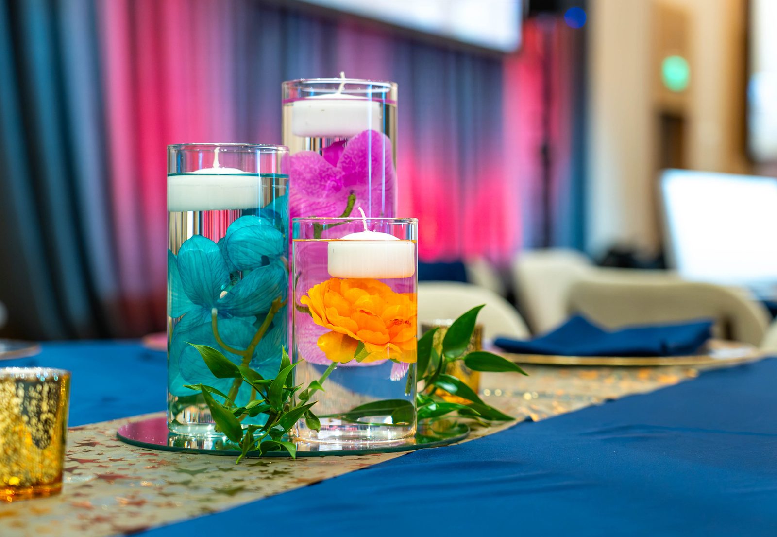 Navy gala tablescape with orchid and floating-candle cylinder centerpiece, gold votive and sequin runner at the PMI Washington DC Chapter Awards Gala, JW Marriott Reston, Virginia