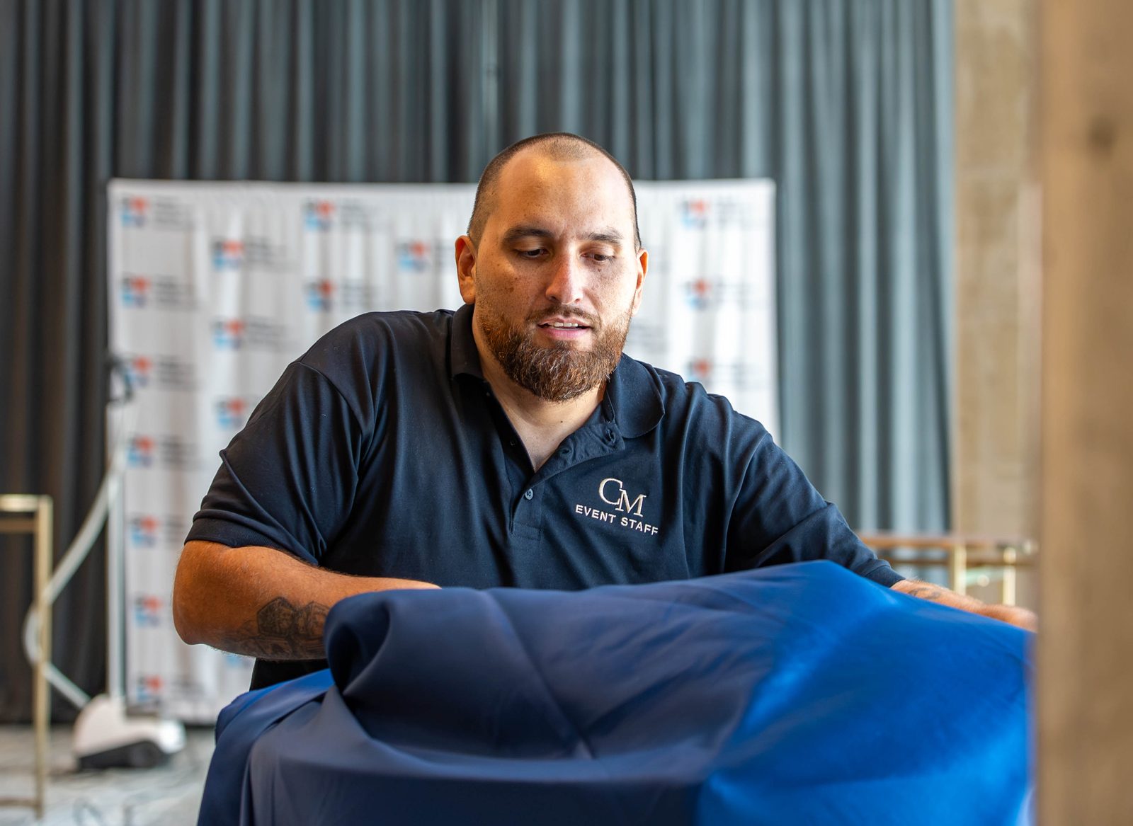 Creative Motion Events team member draping navy linen during setup for the PMI Washington DC Chapter Awards Gala, JW Marriott Reston, Virginia
