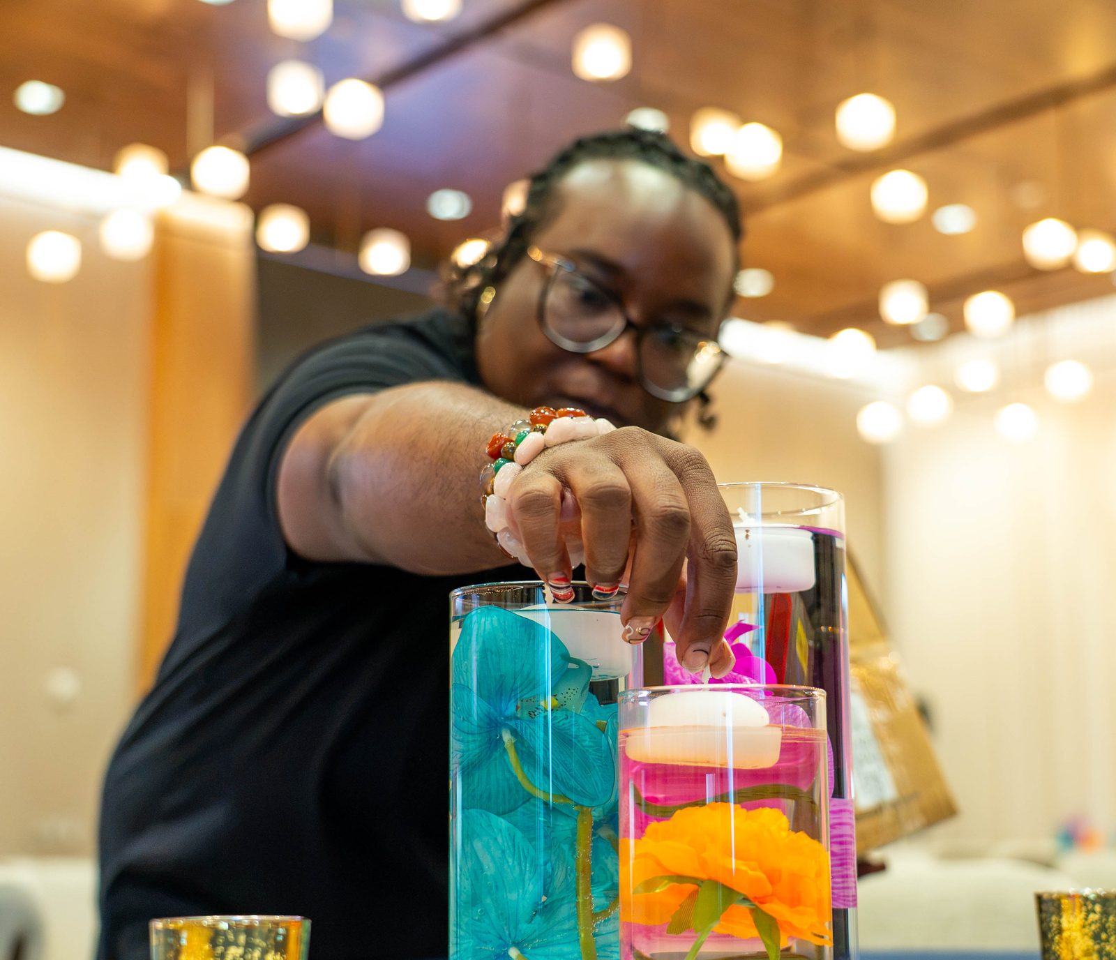 Creative Motion Events team member placing a floating candle in an orchid centerpiece at the PMI Washington DC Chapter Awards Gala, JW Marriott Reston, Virginia