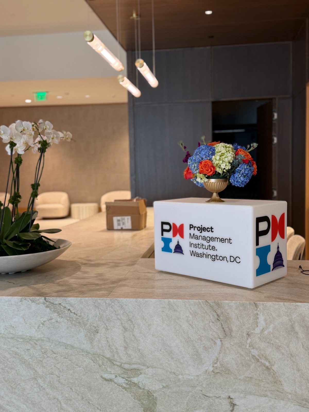 Lit Project Management Institute Washington DC logo cube with floral arrangements in the sponsor lounge, PMI Washington DC Chapter Awards Gala, JW Marriott Reston, Virginia