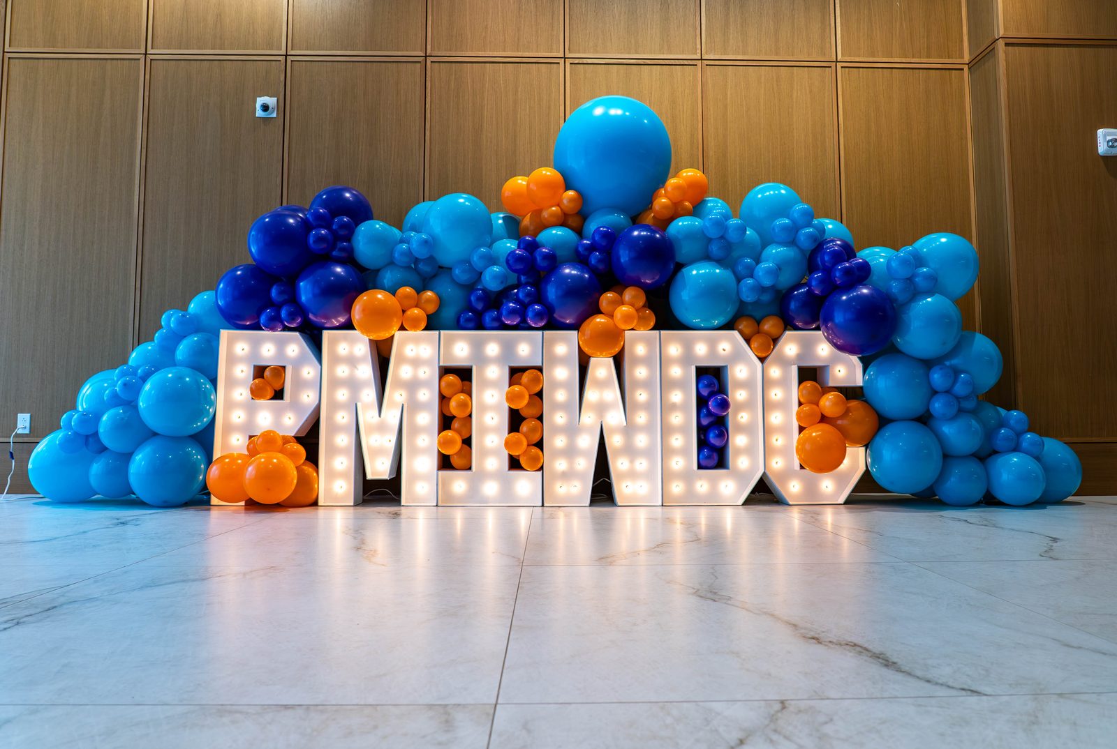 Lit PMIWDC marquee letters under a navy, teal and orange balloon wall at the PMI Washington DC Chapter Awards Gala, JW Marriott Reston, Virginia